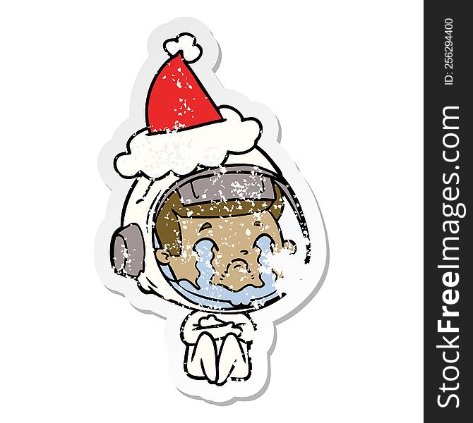 Distressed Sticker Cartoon Of A Crying Astronaut Wearing Santa Hat