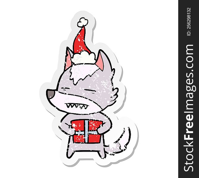 Distressed Sticker Cartoon Of A Wolf With A Gift Wearing Santa Hat