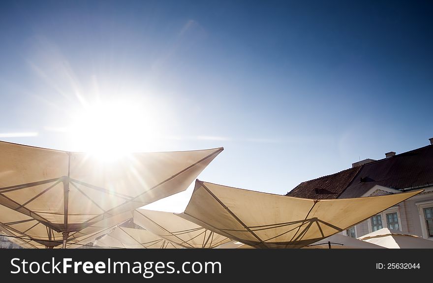 Abstract terrace umbrellas in city and blue sky