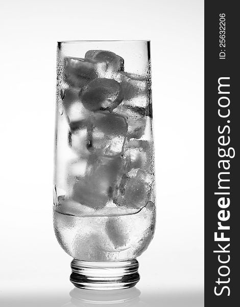 Empty glass with ice cubes on white background