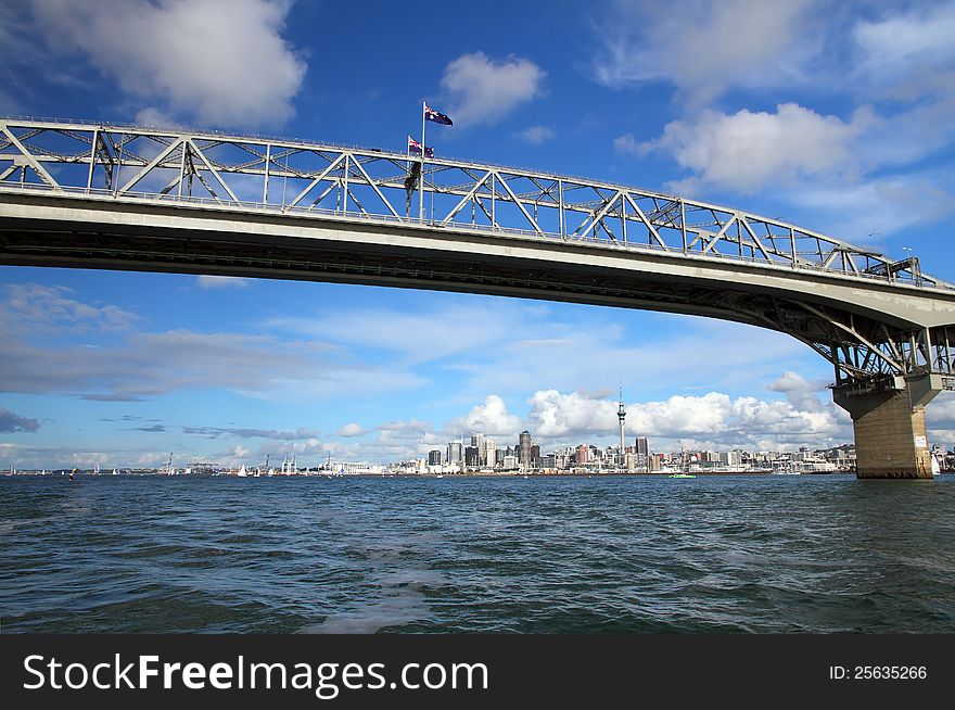 Auckland Harbour Bridge with Auckland City and Sky Tower in the background, New Zealand viewed from the water. Auckland Harbour Bridge with Auckland City and Sky Tower in the background, New Zealand viewed from the water