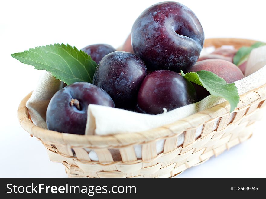 Plums in wooden basket, closeup,