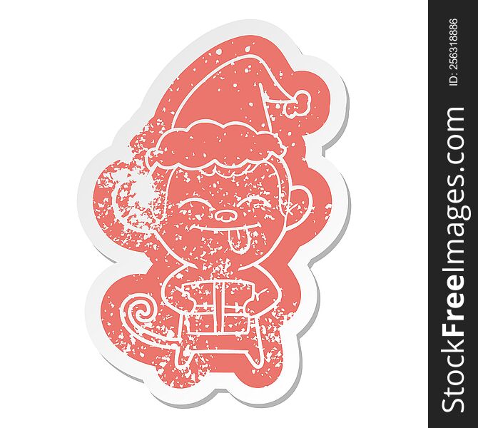 Funny Cartoon Distressed Sticker Of A Monkey With Christmas Present Wearing Santa Hat