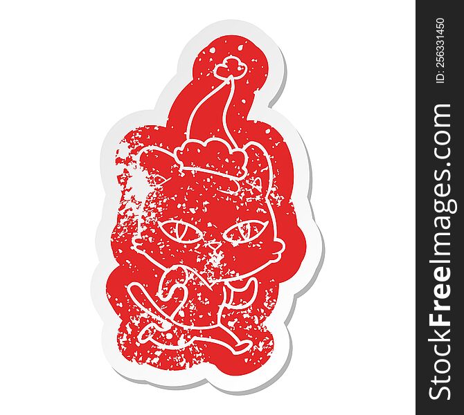 quirky cartoon distressed sticker of a cat out for a run wearing santa hat