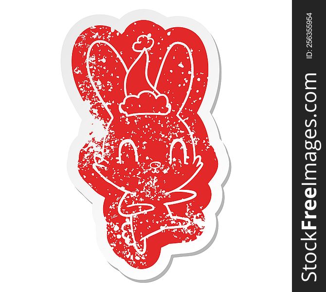 cute quirky cartoon distressed sticker of a rabbit dancing wearing santa hat