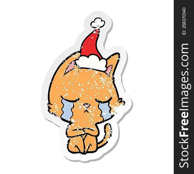 crying hand drawn distressed sticker cartoon of a cat sitting wearing santa hat