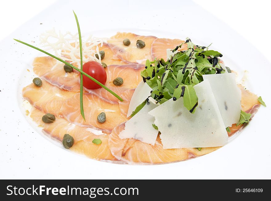 Slices of salmon with herbs and cheese on a white plate