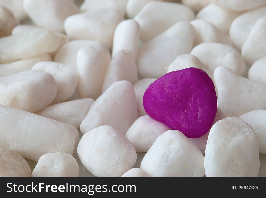 One purple stone in the group of white stone. One purple stone in the group of white stone