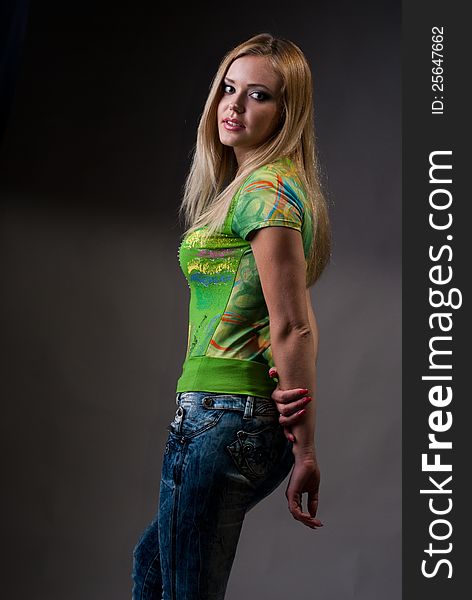Portrait of a girl dressed in a gin, a green t-shirt. Blonde.