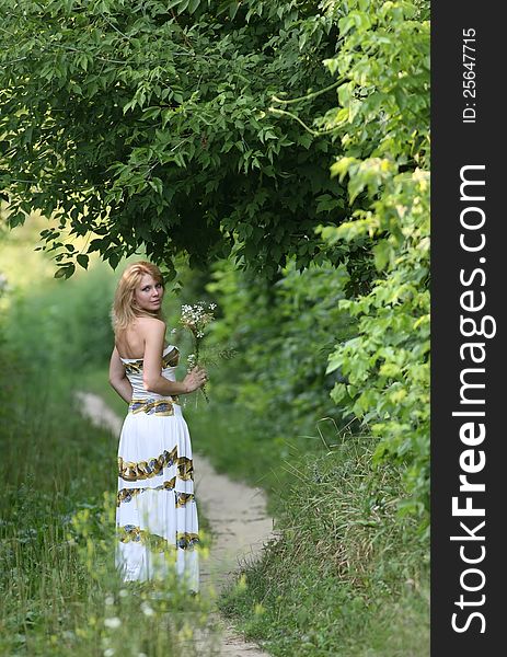 Girl on the forest path with a bouquet of wildflowers. Girl on the forest path with a bouquet of wildflowers