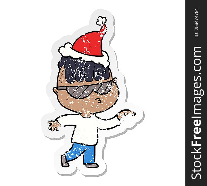 Distressed Sticker Cartoon Of A Boy Wearing Sunglasses Pointing Wearing Santa Hat