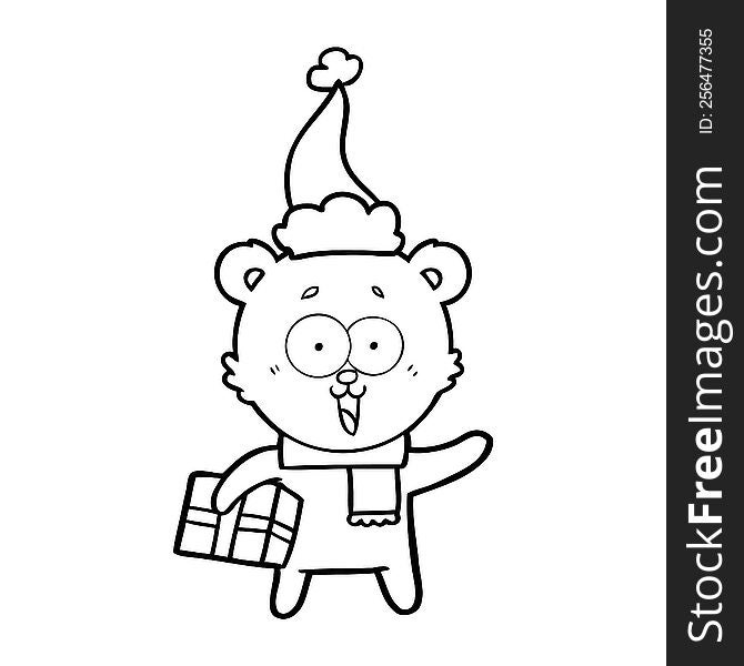 laughing teddy  bear with christmas present wearing santa hat