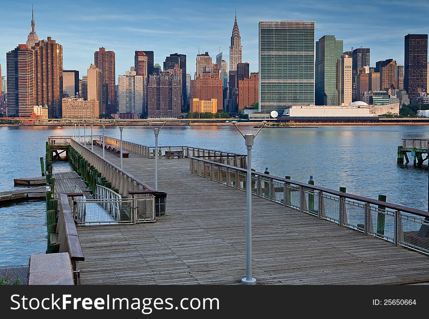 Image of the Manhattan skyline and East River with empty pier in the foreground. Image of the Manhattan skyline and East River with empty pier in the foreground.