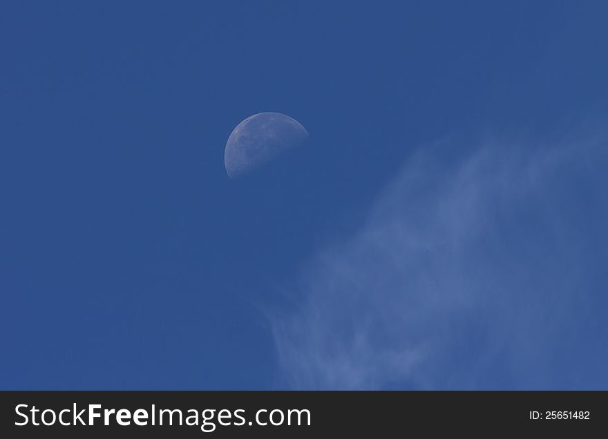 The half moon still visible around mid morning with some very light clouds in the foreground. The half moon still visible around mid morning with some very light clouds in the foreground