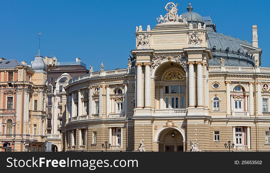 Ornate facade of historical curved building with sculptures, domed roof and pillared balcony. Ornate facade of historical curved building with sculptures, domed roof and pillared balcony