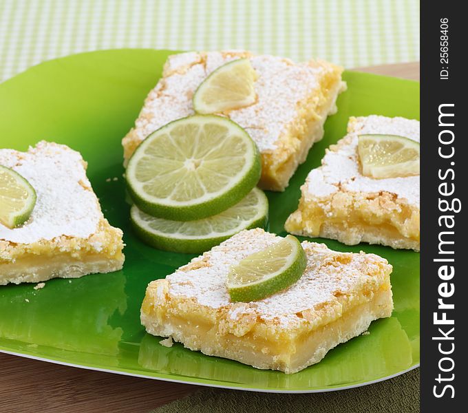 Lime bars on a platter with sliced lime. Lime bars on a platter with sliced lime