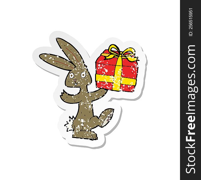 Retro Distressed Sticker Of A Cartoon Rabbit With Christmas Present