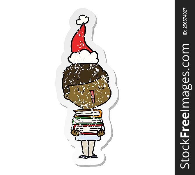 hand drawn distressed sticker cartoon of a happy boy with stack of books wearing santa hat