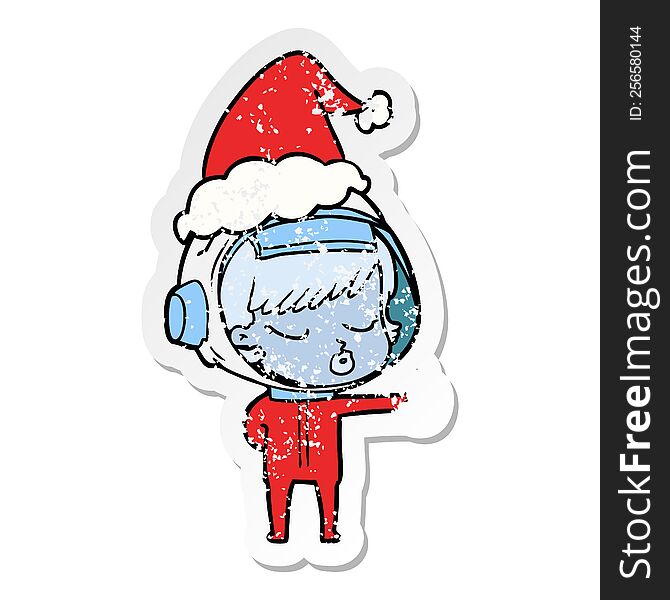 distressed sticker cartoon of a pretty astronaut girl giving thumbs up wearing santa hat