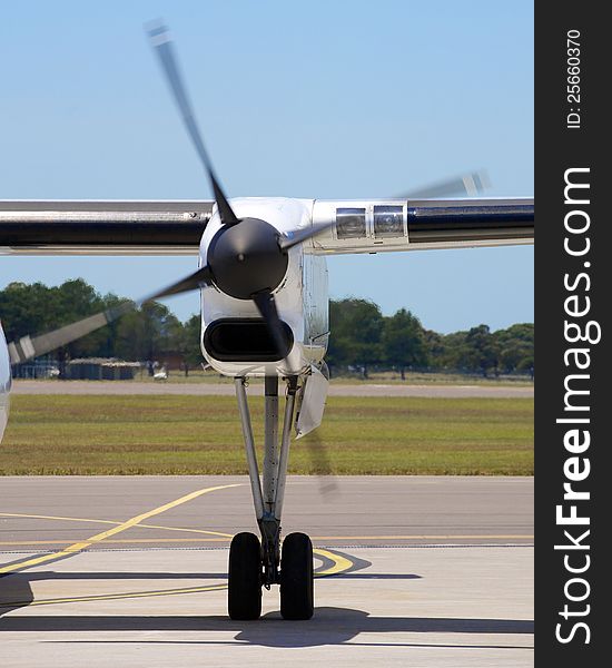 A shot of a turbo prop propeller, taken on the runway of an airport. Blue sky