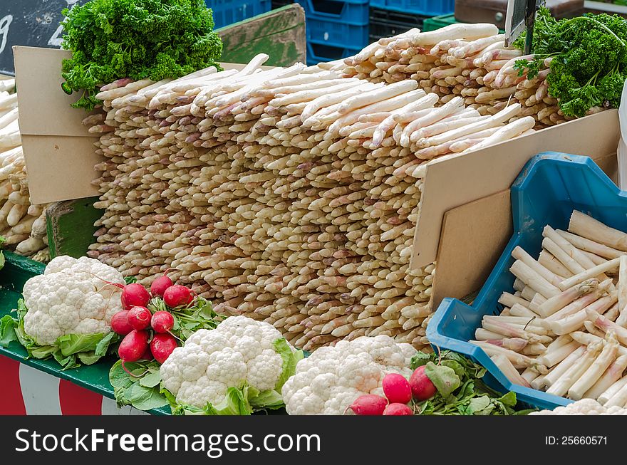 Fresh Asparagus at a market in Germany with cauliflower and red radish for decoration. Fresh Asparagus at a market in Germany with cauliflower and red radish for decoration.