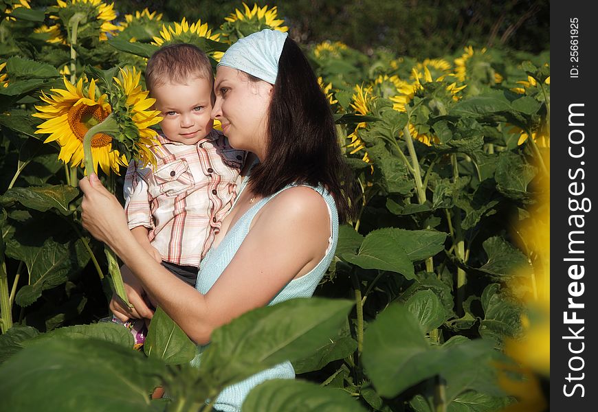 Young mother and her son with sunflower. Young mother and her son with sunflower