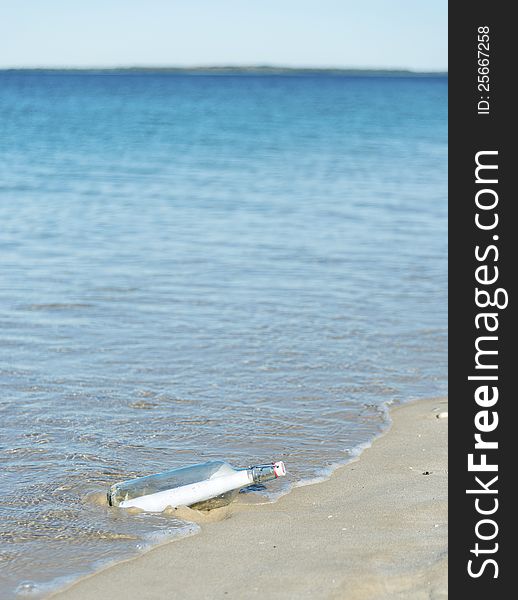 Message in a bottle being washed up on a deserted beach. Copyspace. Message in a bottle being washed up on a deserted beach. Copyspace.