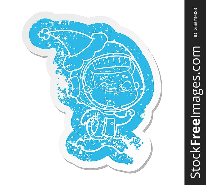 happy quirky cartoon distressed sticker of a astronaut wearing santa hat