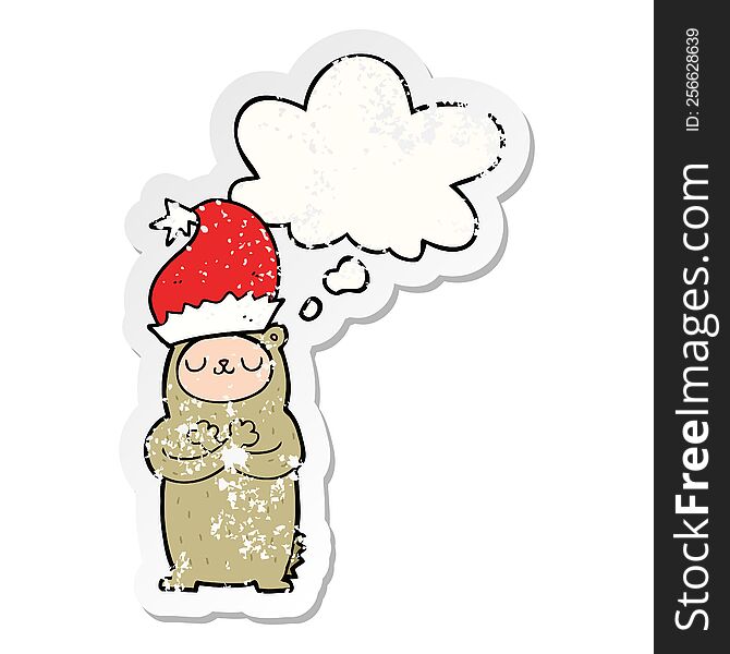 cartoon bear wearing christmas hat with thought bubble as a distressed worn sticker