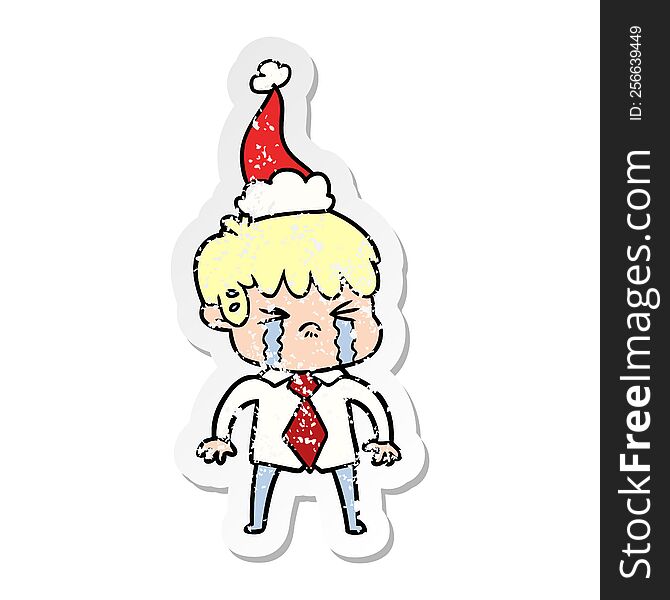 hand drawn distressed sticker cartoon of a boy crying wearing santa hat