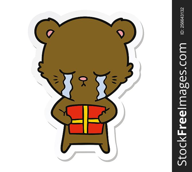 sticker of a crying cartoon bear with present