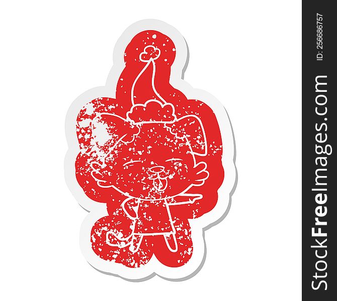 quirky cartoon distressed sticker of a dog sticking out tongue wearing santa hat