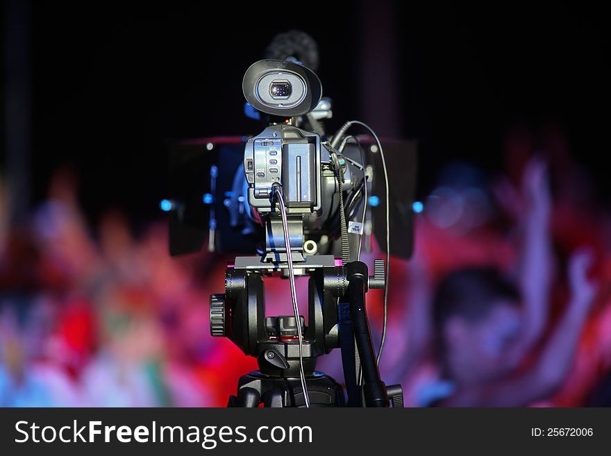 Film camera in front of a cheering crowd