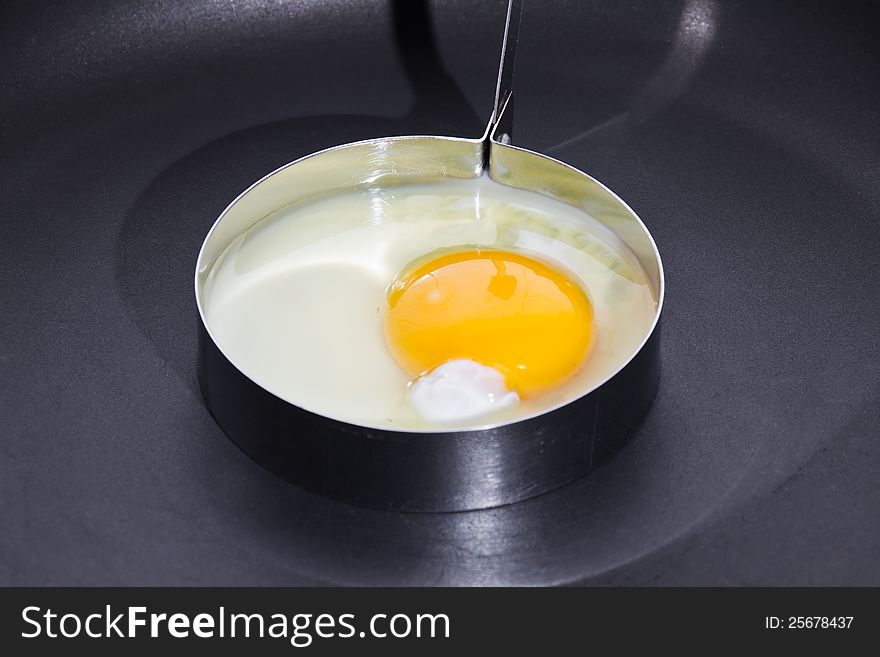 Cooking sunny side up (fried egg) in circle shape on black skillet. Cooking sunny side up (fried egg) in circle shape on black skillet