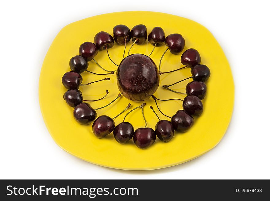 Delicious fresh cherries inside a plate and big plum. Delicious fresh cherries inside a plate and big plum