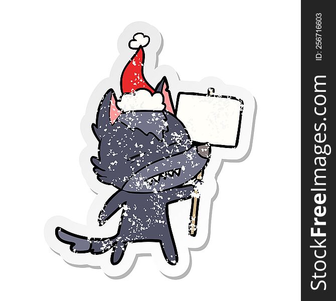 hand drawn distressed sticker cartoon of a wolf with sign post showing teeth wearing santa hat