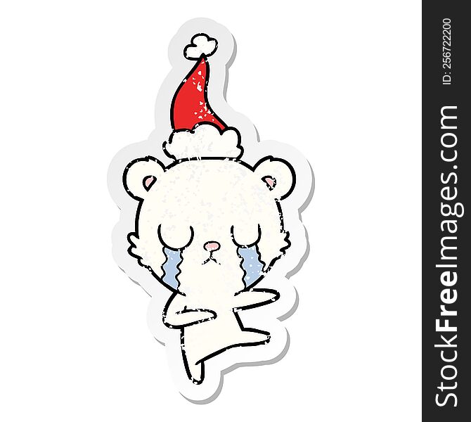 crying polar bear hand drawn distressed sticker cartoon of a wearing santa hat