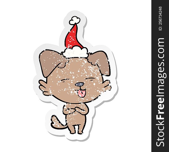 hand drawn distressed sticker cartoon of a dog sticking out tongue wearing santa hat
