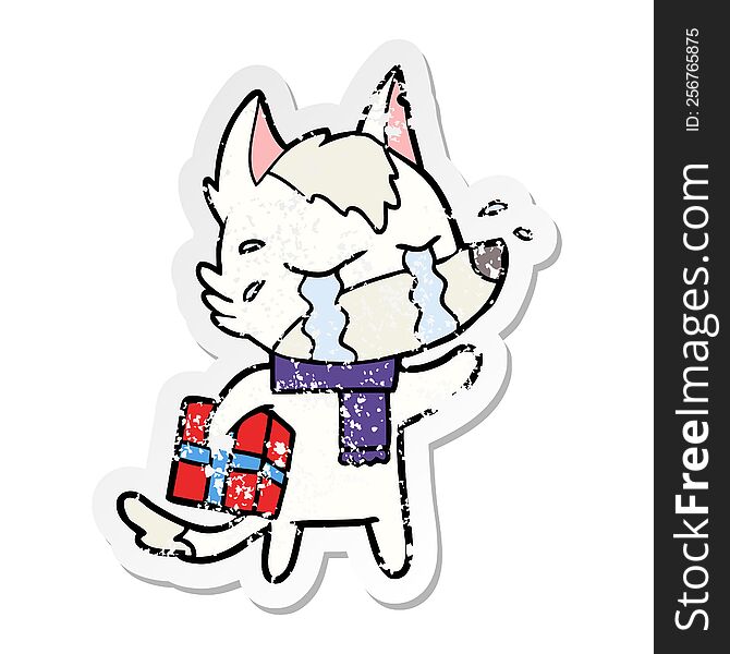 distressed sticker of a cartoon crying wolf with christmas present