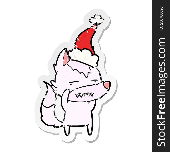 hand drawn distressed sticker cartoon of a wolf showing teeth wearing santa hat