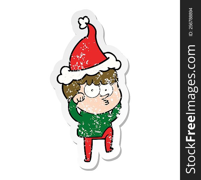 hand drawn distressed sticker cartoon of a curious boy rubbing eyes in disbelief wearing santa hat