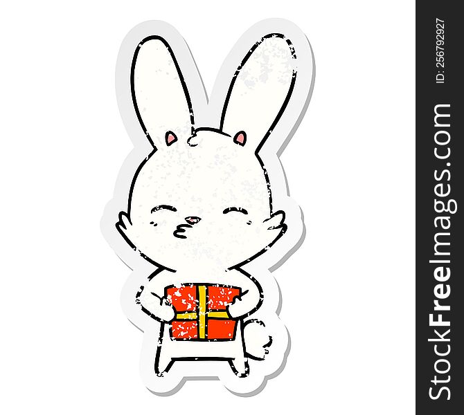 Distressed Sticker Of A Curious Bunny Cartoon With Present