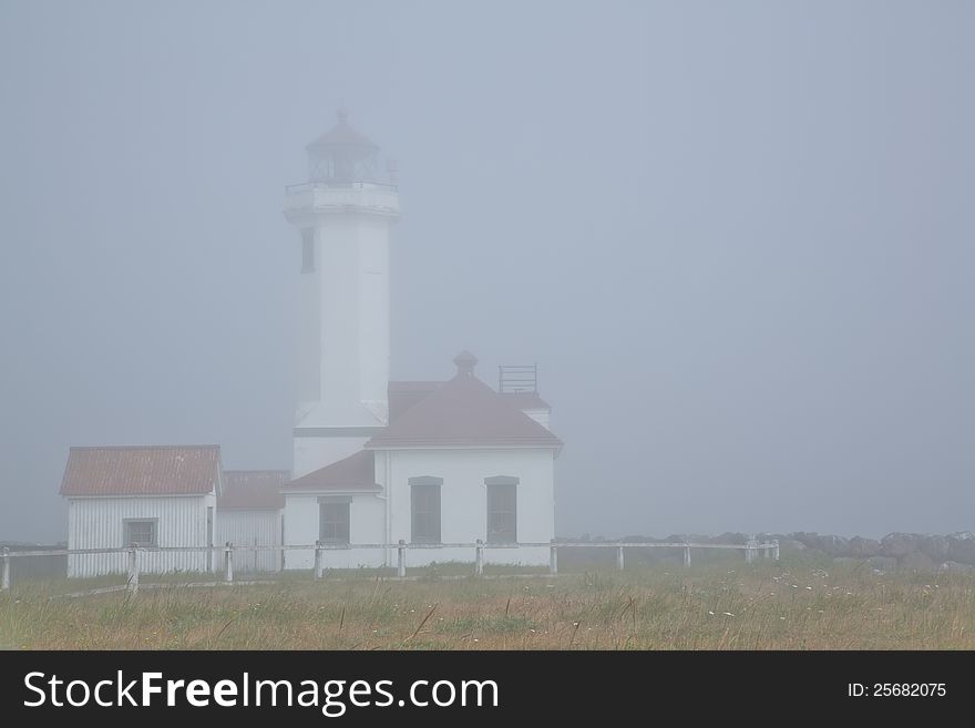 Thick morning fog surrounds the Point Wilson Lighthouse at Fort Worden a Washington State Park. Thick morning fog surrounds the Point Wilson Lighthouse at Fort Worden a Washington State Park