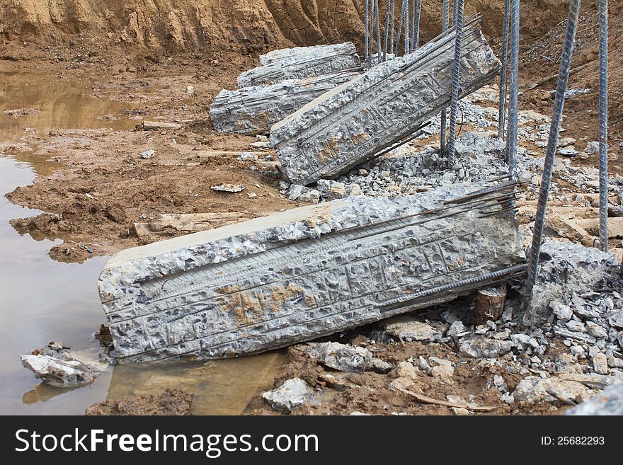 Breaking down concrete piles embedded into the soil to be prepared for a long iron rod. Breaking down concrete piles embedded into the soil to be prepared for a long iron rod.