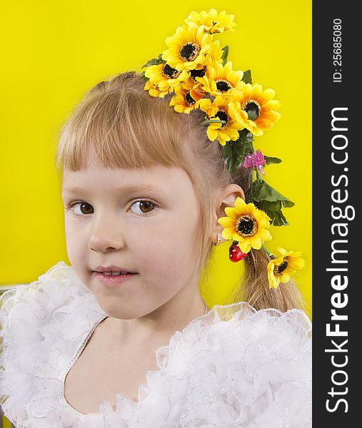 The little girl with yellow flowers in hair. Yellow isolated.