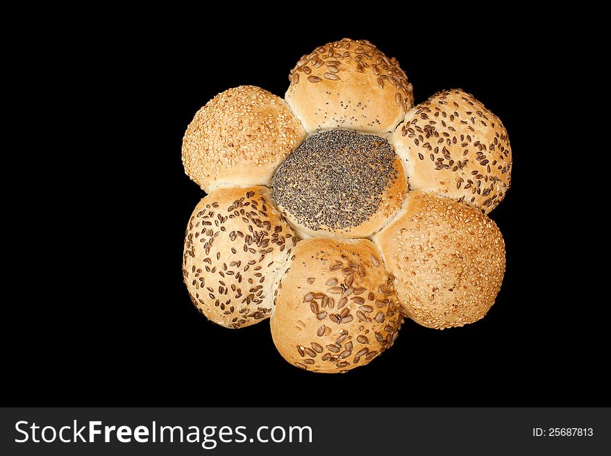 Bread looking lika a flower, full of different seeds. Isolated on black background. Bread looking lika a flower, full of different seeds. Isolated on black background.