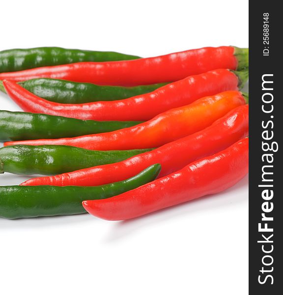 Arrangement of green and red chili peppers isolated on white background