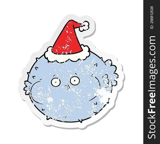 hand drawn distressed sticker cartoon of a puffer fish wearing santa hat