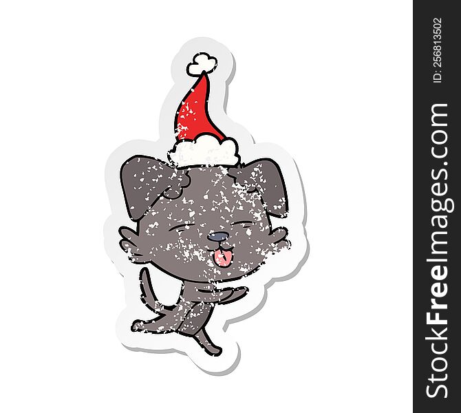 hand drawn distressed sticker cartoon of a dog sticking out tongue wearing santa hat