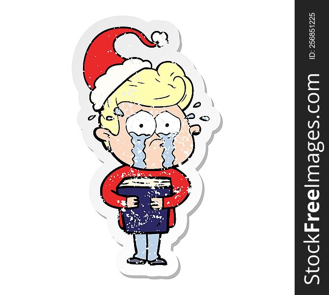 distressed sticker cartoon of a crying man holding book wearing santa hat